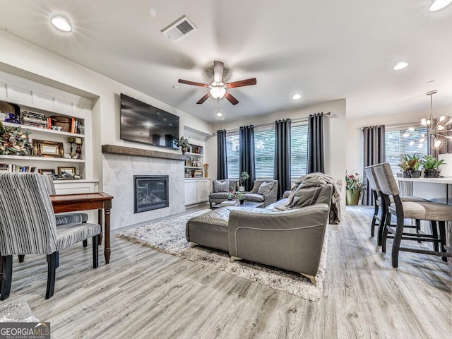 130 Maple Creek Way, Woodstock, GA 30188 - living area with visible vents, ceiling fan with notable chandelier, wood finished floors, and a healthy amount of sunlight