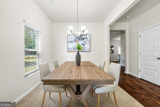 dining space with baseboards, a wealth of natural light, and a chandelier