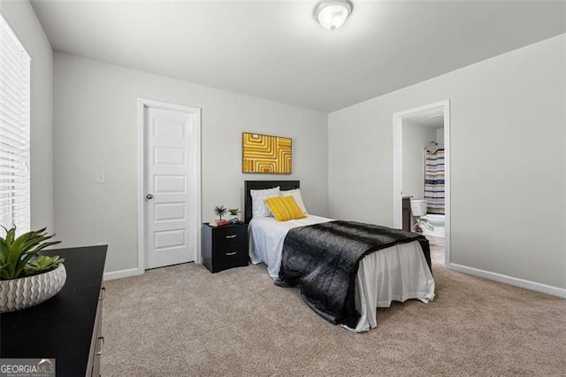 bedroom featuring ensuite bath, baseboards, and light colored carpet