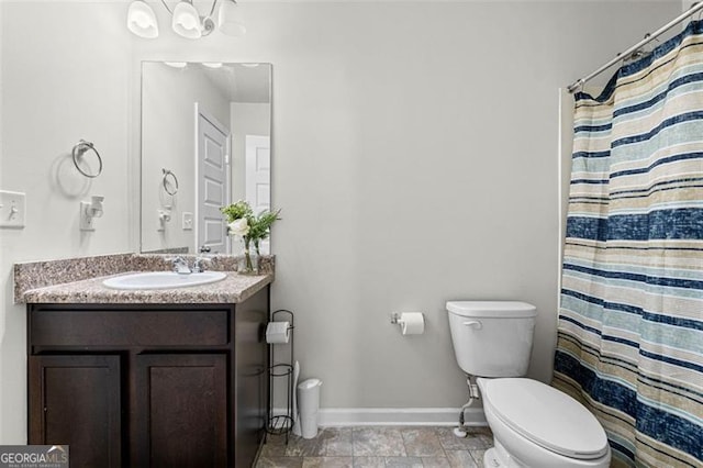 full bathroom featuring baseboards, vanity, and toilet