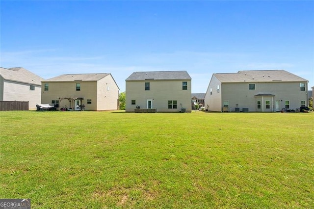 rear view of property featuring a lawn