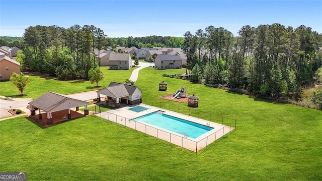 pool featuring fence, a lawn, and a residential view