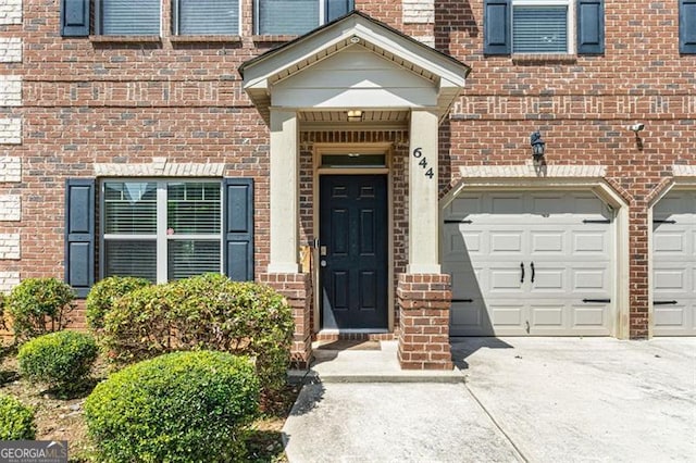 property entrance with brick siding and concrete driveway