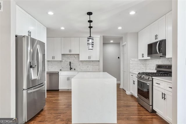100 Little Ridge Rd, Berkeley Lake, GA 30096 - kitchen featuring appliances with stainless steel finishes, decorative backsplash, light countertops, a center island, and dark wood-style flooring