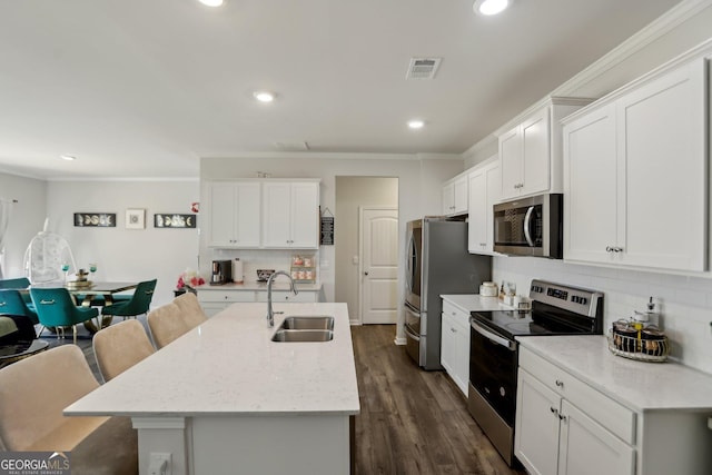 kitchen featuring crown molding, appliances with stainless steel finishes, a sink, tasteful backsplash, and visible vents