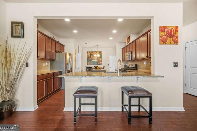 5030 Breezewood Cir, Alpharetta, GA 30004 - kitchen featuring stainless steel microwave, a peninsula, dark wood-style flooring, and a sink