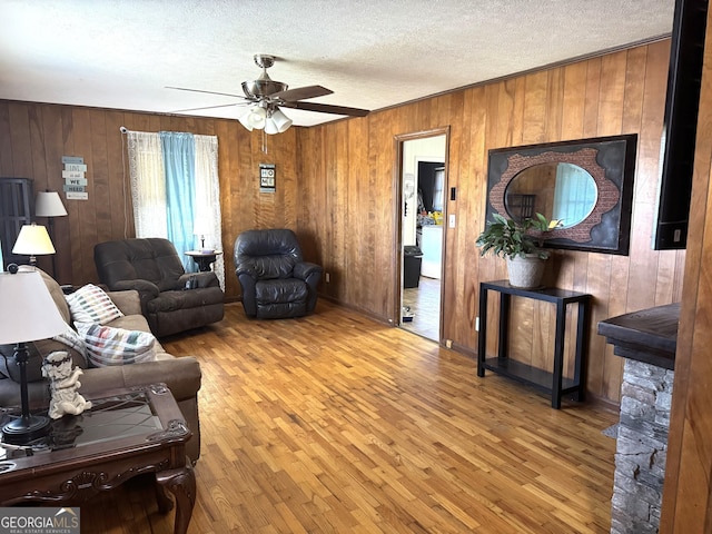 3065 County Road 69, Centre, AL 35960 - living room with wooden walls, wood finished floors, a ceiling fan, and a textured ceiling