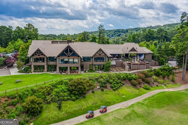 aerial view featuring view of golf course and a view of trees