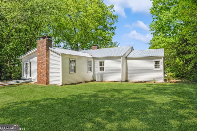 1531 E Broad St, Greensboro, GA 30642 - back of property featuring a chimney, central air condition unit, a yard, and metal roof