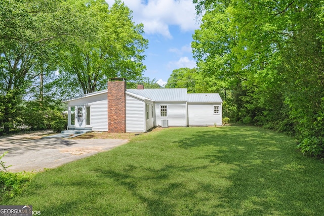 1531 E Broad St, Greensboro, GA 30642 - rear view of property with a chimney, metal roof, and a lawn