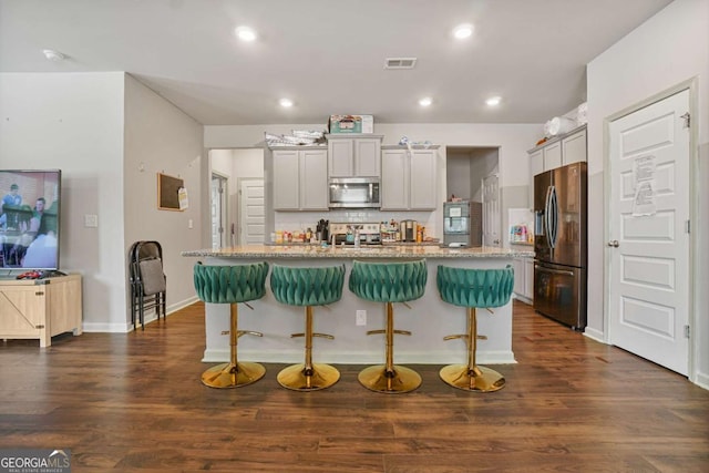 11893 Lovejoy Crossing Blvd, Hampton, GA 30228 - kitchen with stainless steel appliances, a breakfast bar, light stone counters, decorative backsplash, and dark wood-style floors