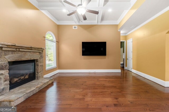 unfurnished living room with beam ceiling, visible vents, coffered ceiling, wood finished floors, and a stone fireplace