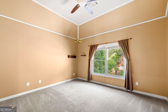 carpeted spare room featuring ceiling fan, baseboards, ornamental molding, and visible vents