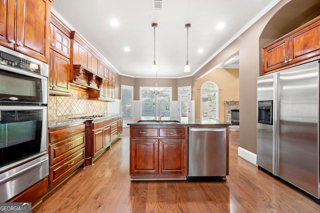 kitchen with dark wood-style floors, stainless steel appliances, a sink, a warming drawer, and a fireplace