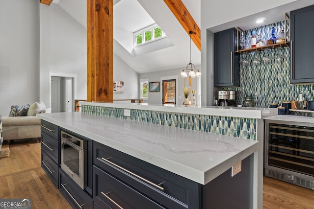 5527 Little River Cir, Gainesville, GA 30506 - indoor dry bar with beverage cooler, built in microwave, wood finished floors, high vaulted ceiling, and hanging light fixtures