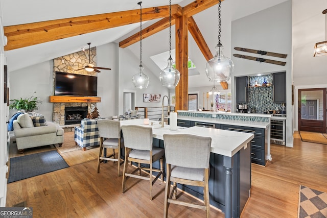 5527 Little River Cir, Gainesville, GA 30506 - kitchen featuring beverage cooler, a large island with sink, open floor plan, ceiling fan, and high vaulted ceiling