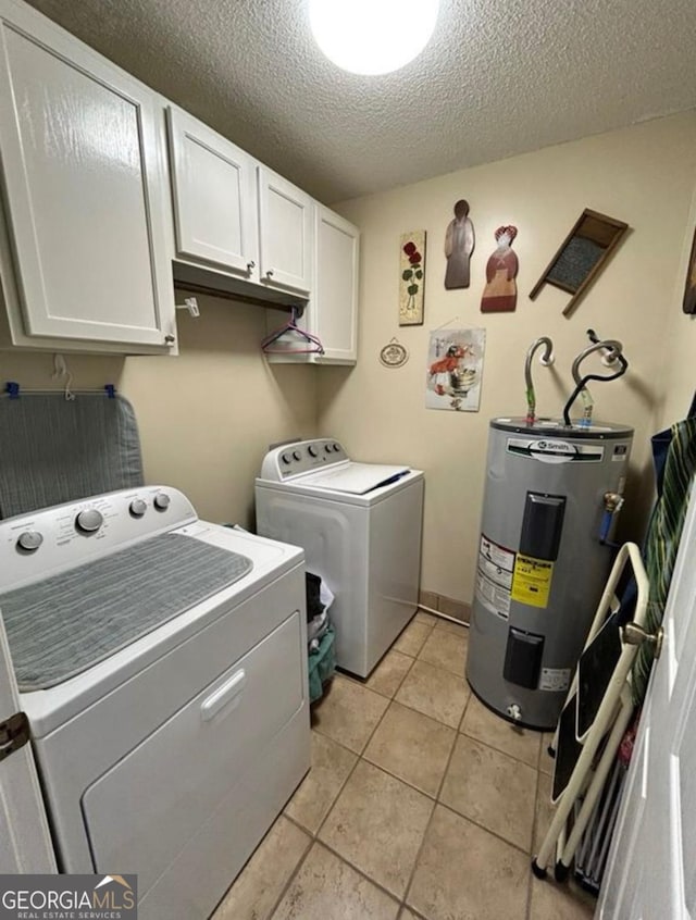 2118 Deer Run Cir, Tifton, GA 31793 - clothes washing area featuring washing machine and clothes dryer, electric water heater, cabinet space, a textured ceiling, and light tile patterned floors