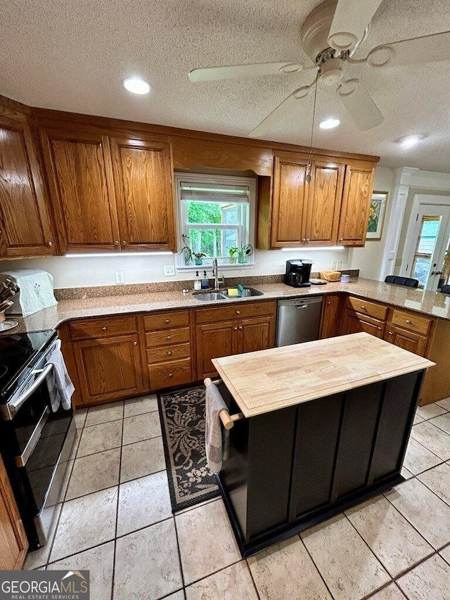 2118 Deer Run Cir, Tifton, GA 31793 - kitchen featuring a sink, stainless steel appliances, brown cabinetry, a peninsula, and a ceiling fan