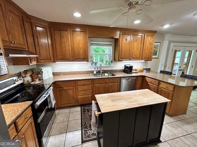 2118 Deer Run Cir, Tifton, GA 31793 - kitchen featuring stainless steel appliances, a peninsula, under cabinet range hood, a sink, and brown cabinets