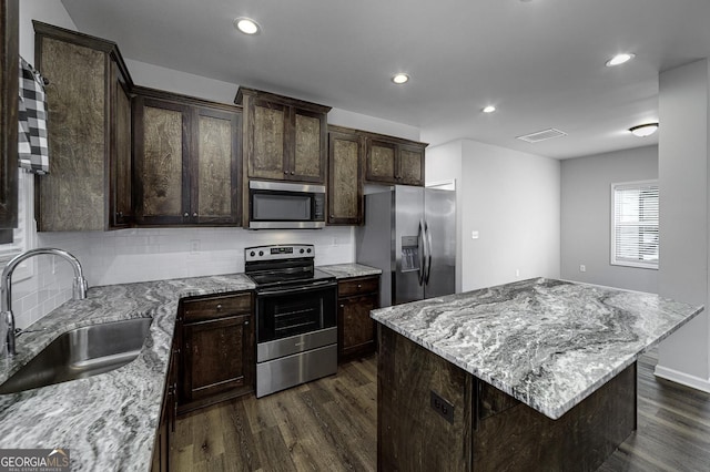 1575 Cabin Creek Trl, Griffin, GA 30223 - kitchen with a sink, dark wood-style flooring, dark brown cabinets, decorative backsplash, and appliances with stainless steel finishes