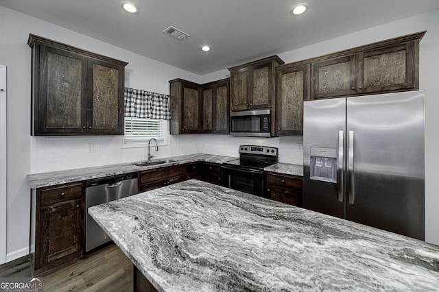 1575 Cabin Creek Trl, Griffin, GA 30223 - kitchen featuring visible vents, wood finished floors, light stone counters, a sink, and appliances with stainless steel finishes