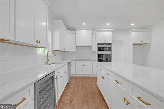 kitchen featuring beverage cooler, a sink, white cabinetry, and stainless steel appliances