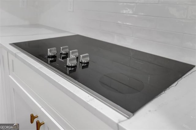 room details featuring light countertops and black electric stovetop