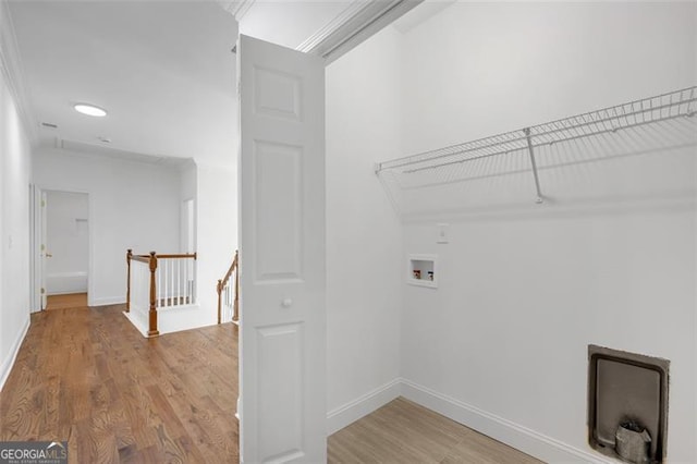laundry area with laundry area, hookup for a washing machine, baseboards, and light wood-type flooring