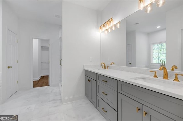 bathroom with a sink, baseboards, a stall shower, and double vanity