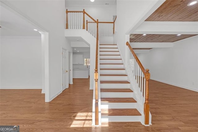 stairs featuring recessed lighting, ornamental molding, baseboards, and wood finished floors