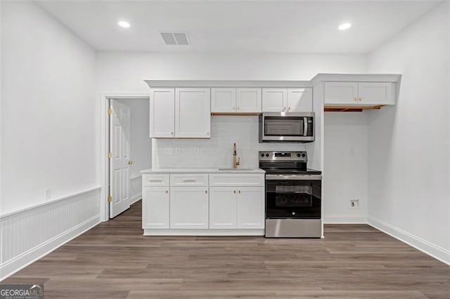 kitchen featuring decorative backsplash, visible vents, appliances with stainless steel finishes, light countertops, and white cabinetry