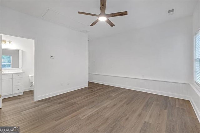 interior space featuring visible vents, attic access, light wood-style floors, and multiple windows