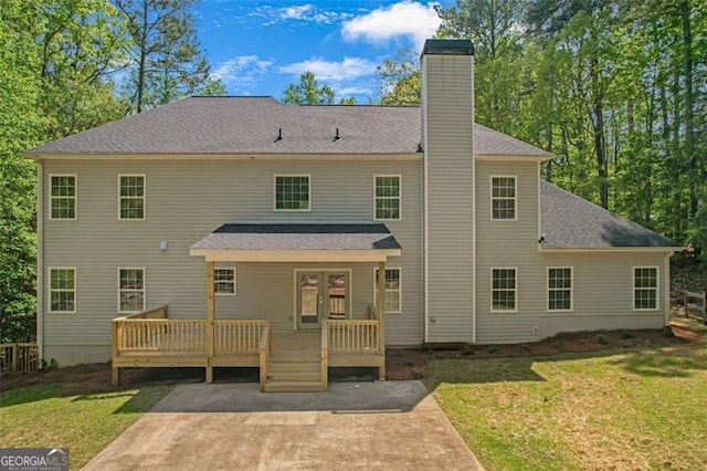 back of house with a yard, a deck, a chimney, and a patio