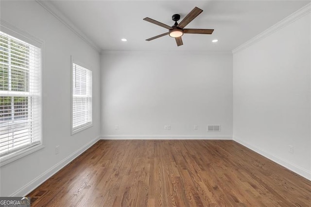 spare room featuring ceiling fan, visible vents, ornamental molding, and wood finished floors