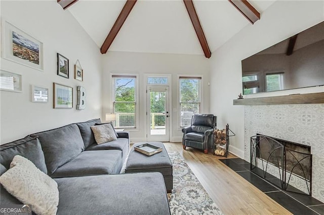 2244 Spink St NW, Atlanta, GA 30318 - living room featuring wood finished floors, high vaulted ceiling, beamed ceiling, and a tiled fireplace