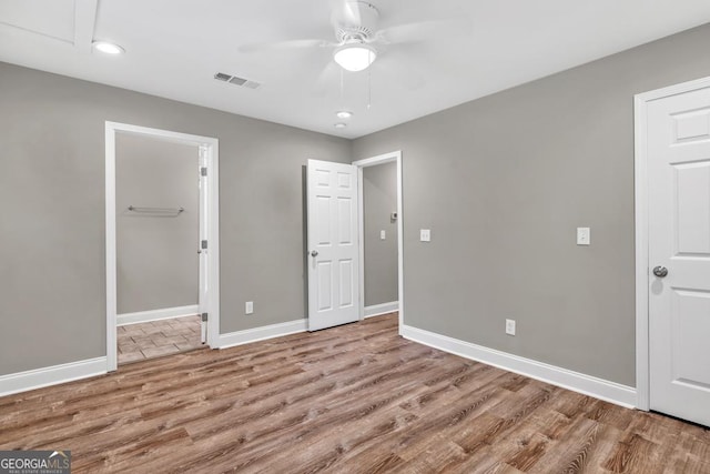 unfurnished bedroom with recessed lighting, visible vents, wood finished floors, and baseboards