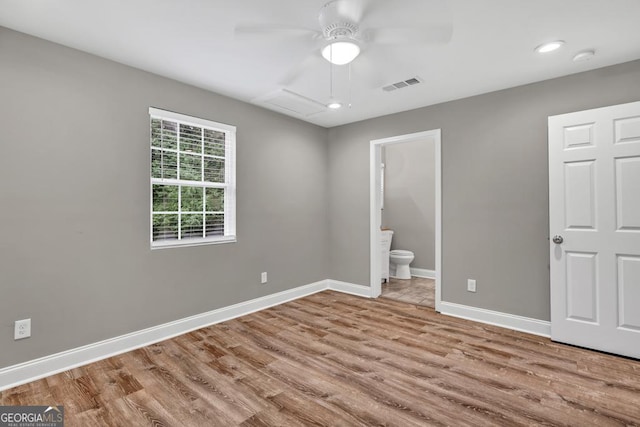 unfurnished bedroom with recessed lighting, ensuite bath, visible vents, baseboards, and wood finished floors