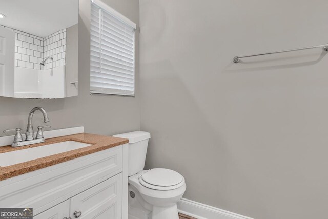 bathroom with a shower, vanity, and toilet