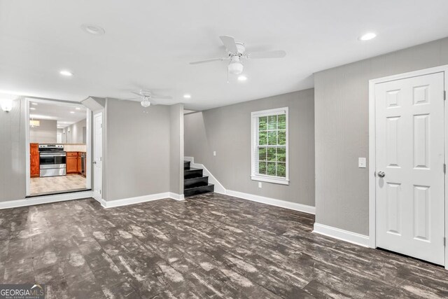 basement with a ceiling fan, stairway, and baseboards