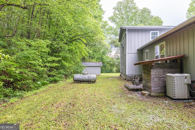 view of yard with an outbuilding, a storage unit, and central AC unit