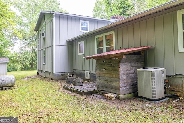 back of property with a lawn, a chimney, cooling unit, and crawl space