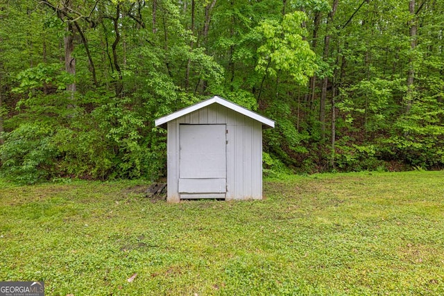 view of shed with a wooded view