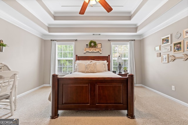 bedroom featuring light carpet, visible vents, a raised ceiling, and crown molding
