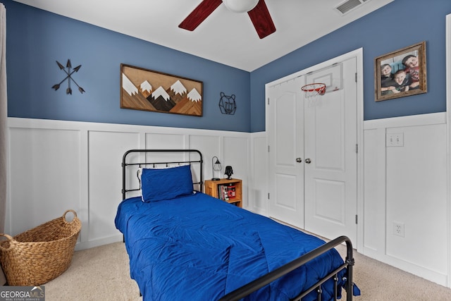 bedroom with wainscoting, carpet floors, a decorative wall, and visible vents