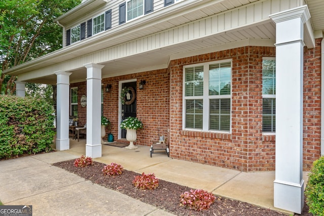 property entrance featuring brick siding and a porch