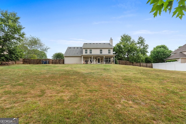 back of property with a lawn, a fenced backyard, and a chimney