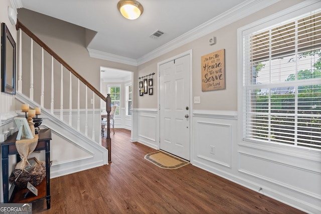 entryway with wainscoting, visible vents, wood finished floors, stairs, and ornamental molding