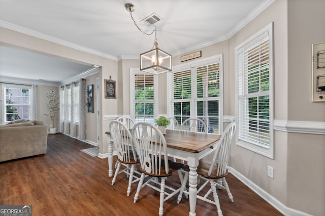 dining space featuring baseboards, visible vents, a chandelier, wood finished floors, and crown molding