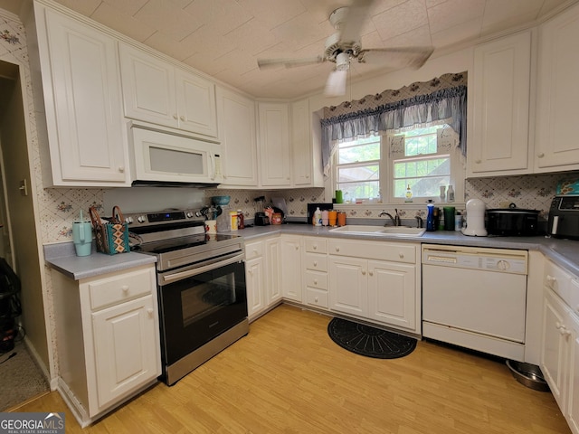 206 New Dr, Claxton, GA 30417 - kitchen featuring backsplash, a sink, white cabinets, light wood-style floors, and white appliances