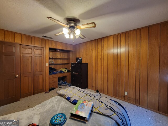206 New Dr, Claxton, GA 30417 - carpeted bedroom featuring visible vents, wood walls, and ceiling fan